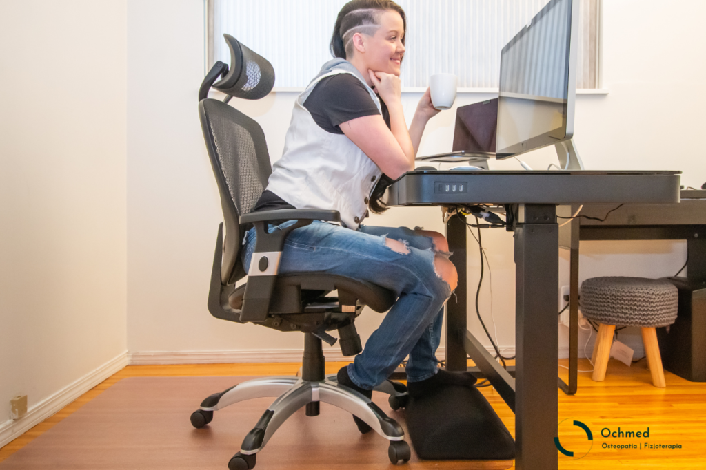 Kobieta przy biurku na ergonomicznym krześle. Znaczenie ergonomii
