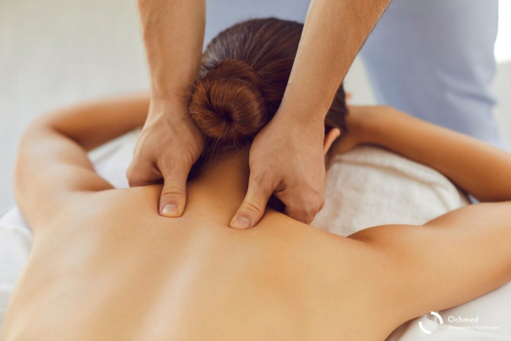 Kobieta w trakcie masażu kręgosłupa - rozluźnianie napięć w szyi - osteopatia, fizjoterapia
