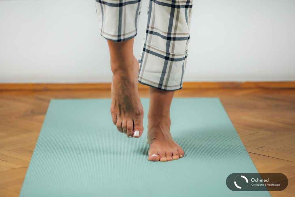 Mężczyzna stoi na jednej nodze. Test na równowagę. Profilaktyka upadków steniorów