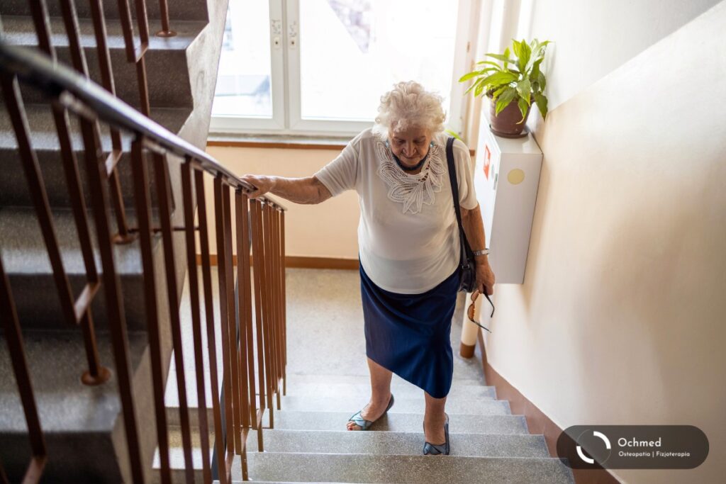 Starsza kobieta wchodzi po schodach. Sarkopenia - starość