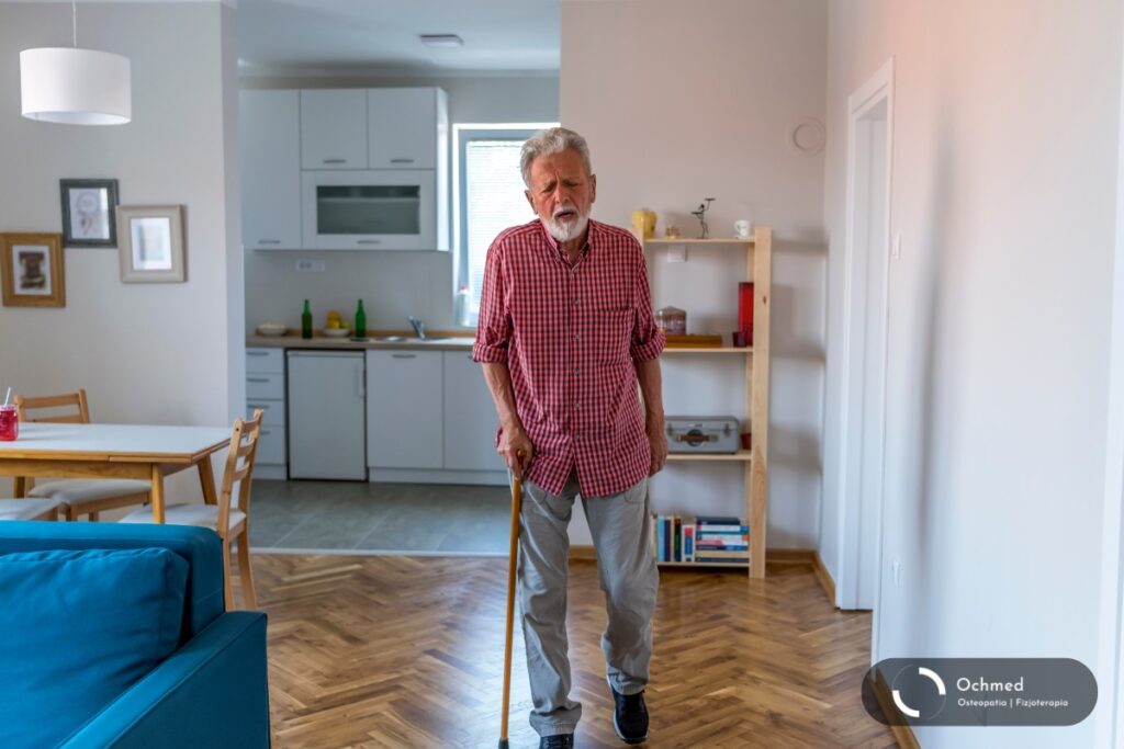 Starszy człowiek idzie o lasce po swoim pokoju. Sarkopenia - starość. Jak zapobiegać?